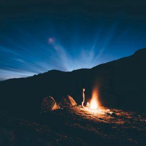 Survive the Apocalypse around a campfire in the mountains.